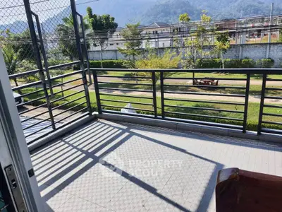 Spacious balcony with scenic view of lush greenery and distant mountains, perfect for relaxation.