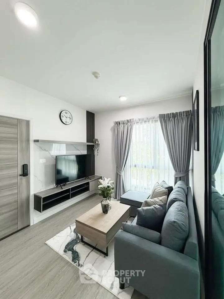 Modern living room with sleek furniture and natural light, featuring a cozy sofa and stylish decor.