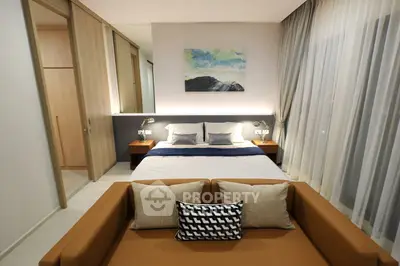Modern bedroom with stylish decor and cozy seating area, featuring elegant lighting and a serene atmosphere.