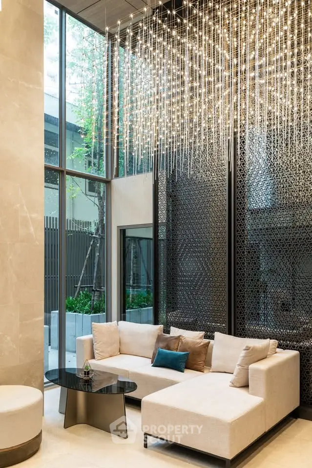 Luxurious modern living room with elegant chandelier and floor-to-ceiling windows