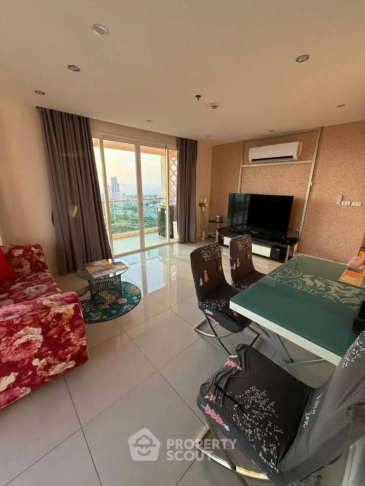 Spacious living room with modern decor and stunning city view from balcony.