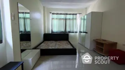 Spacious and well-lit bedroom with glossy tiled flooring, modern furnishings, and a serene ambiance, perfect for relaxation and comfort.