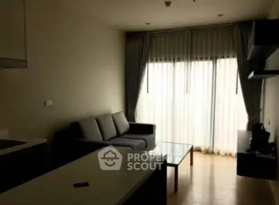 Cozy living room with modern sofa and large window with curtains.