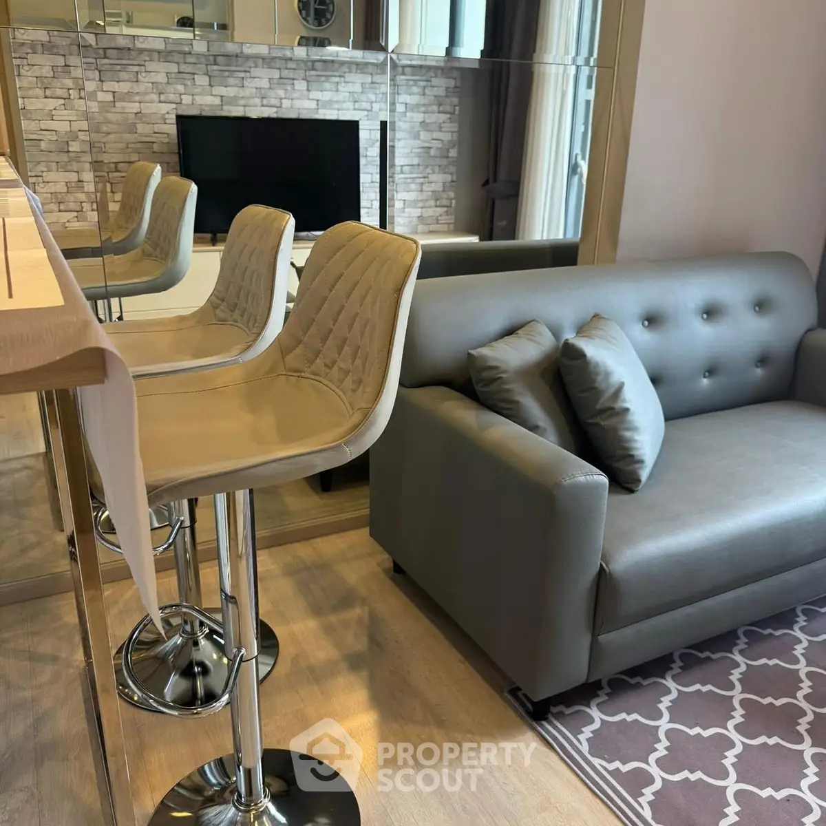 Modern living room with stylish bar stools and cozy sofa, perfect for urban living.