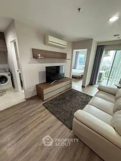 Modern living room with TV, air conditioning, and cozy sofa in a stylish apartment.