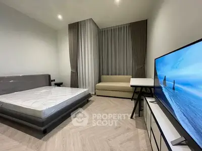 Modern bedroom with sleek furniture and large TV, perfect for relaxation.