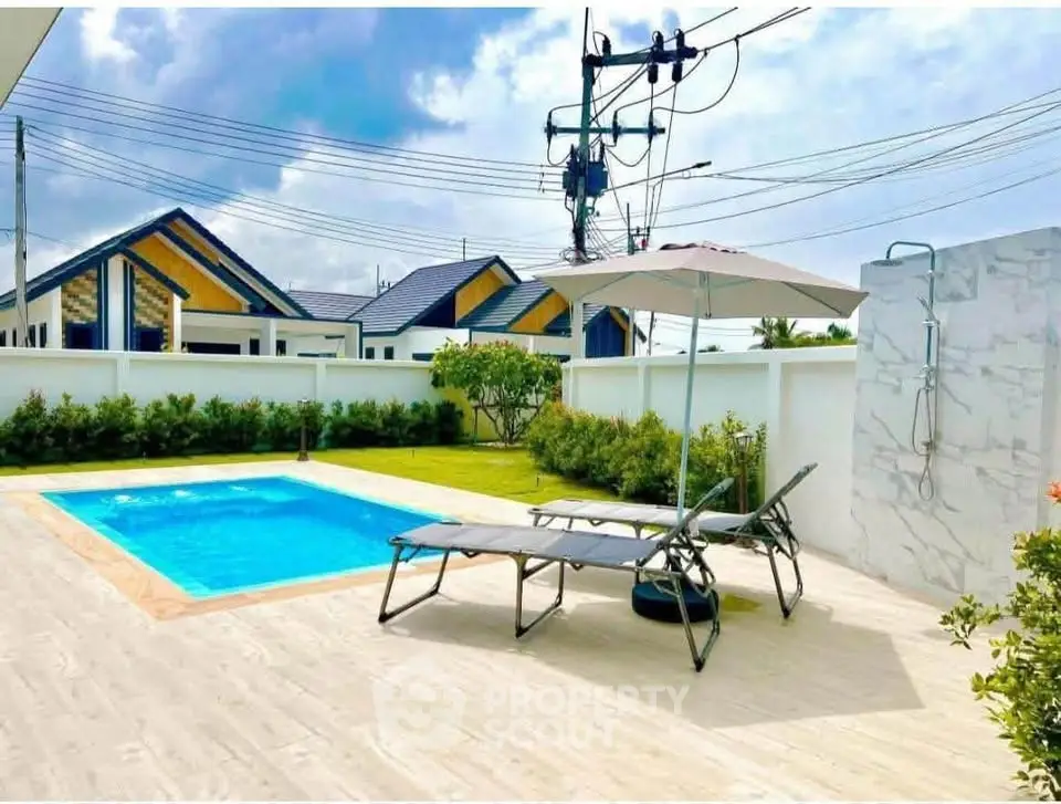 Luxurious private pool area with sun loungers and outdoor shower, perfect for relaxation and leisure.