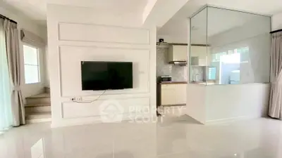 Modern living room with wall-mounted TV and open kitchen layout
