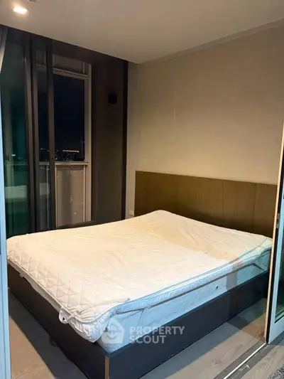 Modern bedroom with large windows and cozy bed in a high-rise apartment.