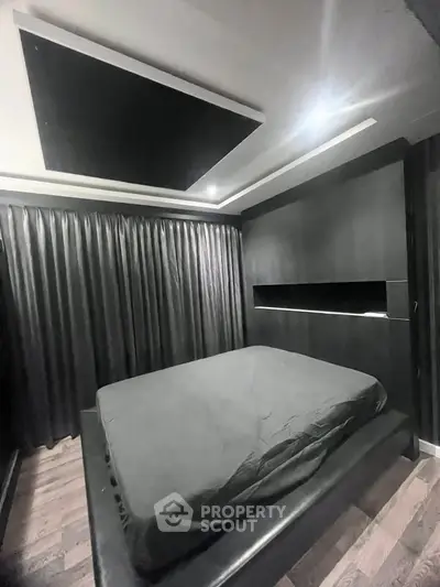 Modern bedroom with sleek black design and ambient lighting