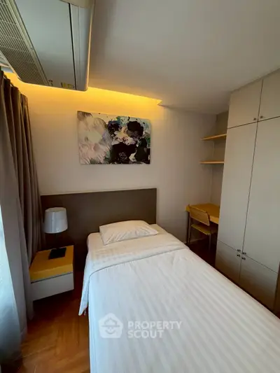 Cozy single bedroom with modern decor and built-in storage, perfect for urban living.