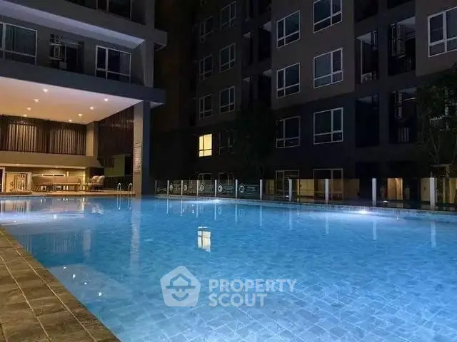 Luxurious condominium with illuminated outdoor pool and modern architecture at night.