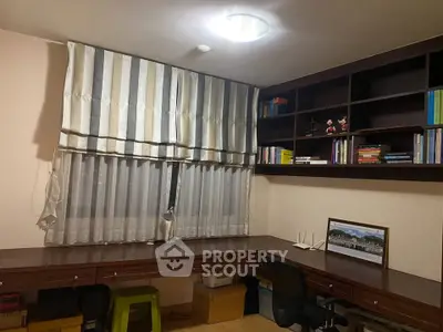 Spacious study room with built-in desk and shelves, perfect for productivity.