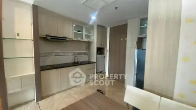 Modern compact kitchen with sleek cabinetry and integrated appliances in a cozy apartment setting.