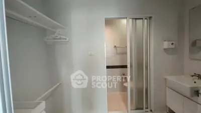 Compact bathroom with sliding door and adjacent sink area