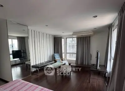Spacious modern living room with large windows and stylish furniture in a high-rise apartment.