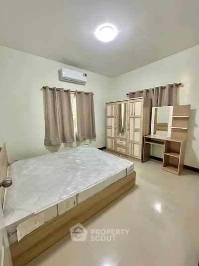 Spacious bedroom with modern furniture and natural light, featuring a comfortable bed and stylish wardrobe.