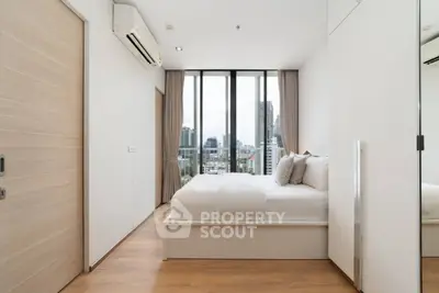 Modern bedroom with city view, featuring sleek design and large windows for natural light.