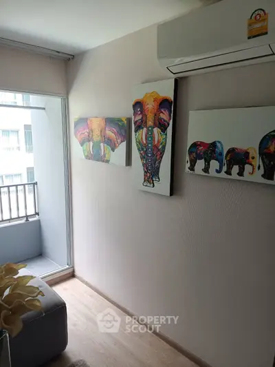 Modern living room with vibrant elephant artwork and balcony access