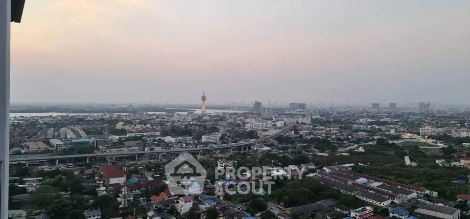 Stunning panoramic cityscape view from high-rise apartment balcony at sunset.