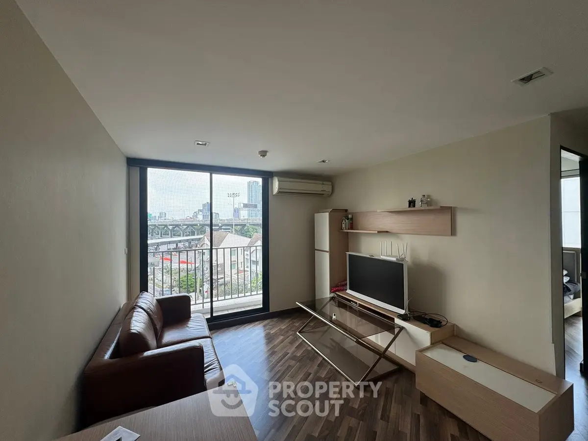 Modern living room with city view, featuring sleek furniture and large windows for natural light.