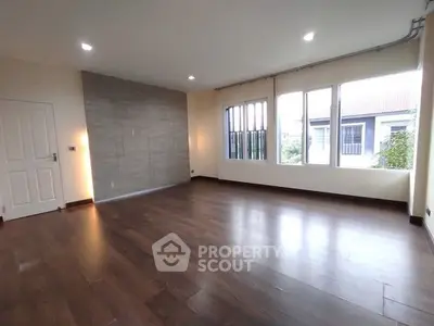 Spacious empty living room with large windows and wooden flooring