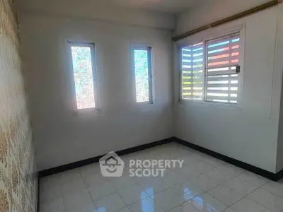 Bright empty room with tiled floor and large windows, perfect for customization.