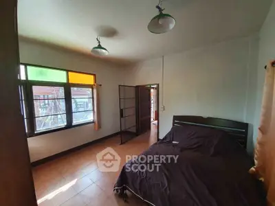 Spacious bedroom with large windows and natural light in a cozy home.