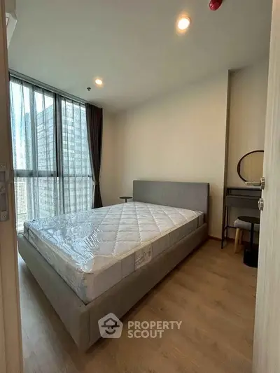 Modern bedroom with large window and stylish furniture in urban apartment