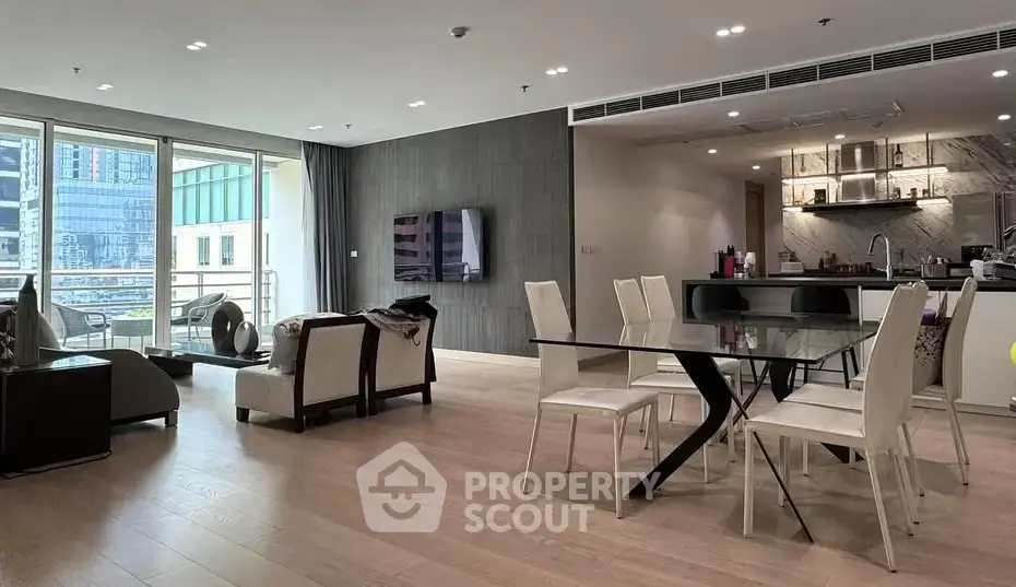 Spacious modern living room with open kitchen and large balcony view.