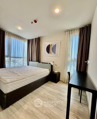 Modern bedroom with large windows and stylish decor in a high-rise apartment.
