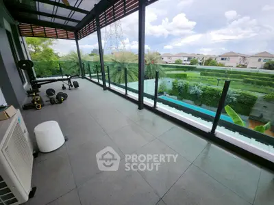 Spacious balcony with gym equipment and scenic garden view