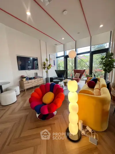 Stylish modern living room with vibrant furniture and large windows