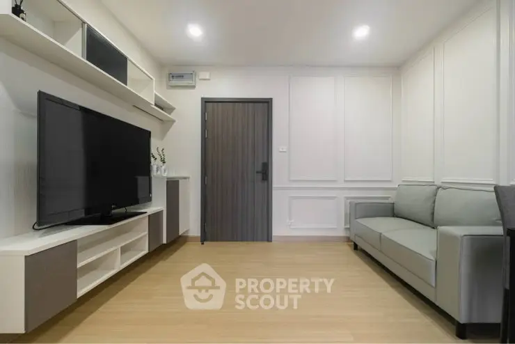 Modern living room with sleek design, featuring a large TV and comfortable sofa, perfect for relaxation.