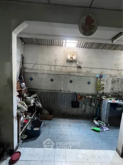 Spacious kitchen with open layout and ample storage potential, featuring tiled walls and natural light.