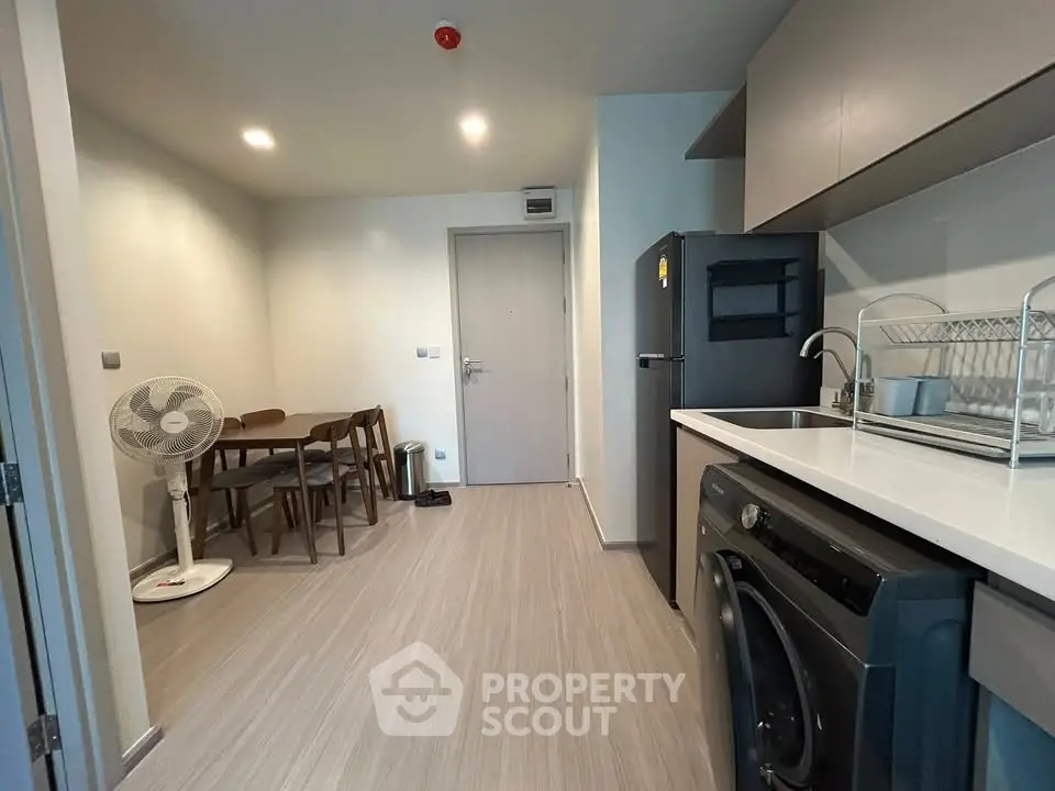 Modern kitchen with sleek appliances and dining area in a stylish apartment.