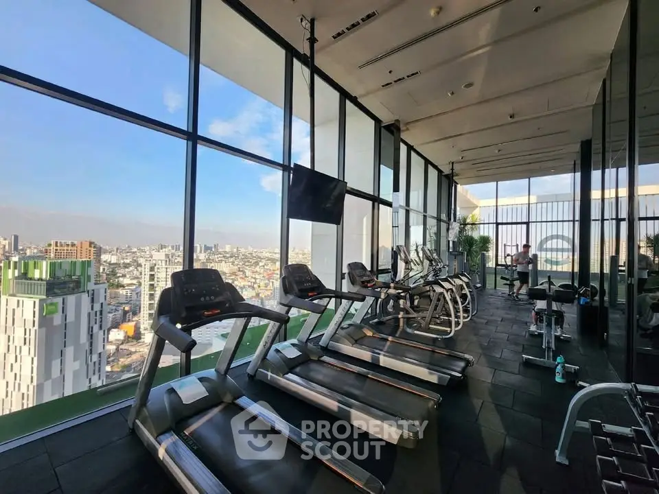 Stunning high-rise gym with panoramic city views and modern fitness equipment.