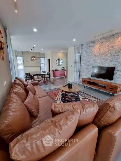 Spacious living room with leather sofa and modern decor in a stylish apartment.