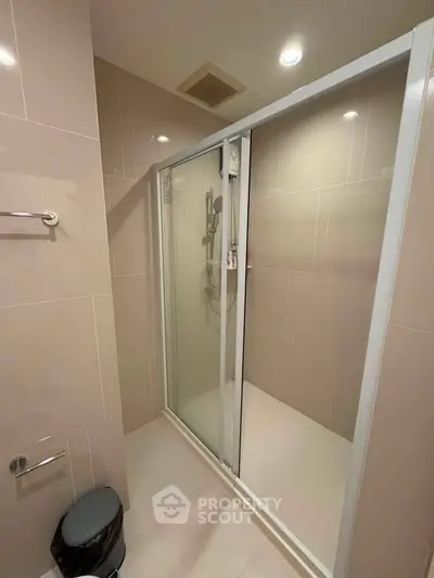 Modern bathroom with glass shower enclosure and sleek tile design.