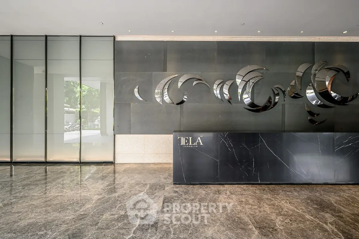 Luxurious modern building entrance with sleek marble floors and artistic wall design.
