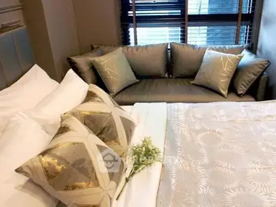 Luxurious bedroom with elegant bedding and stylish sofa, perfect for relaxation and comfort.