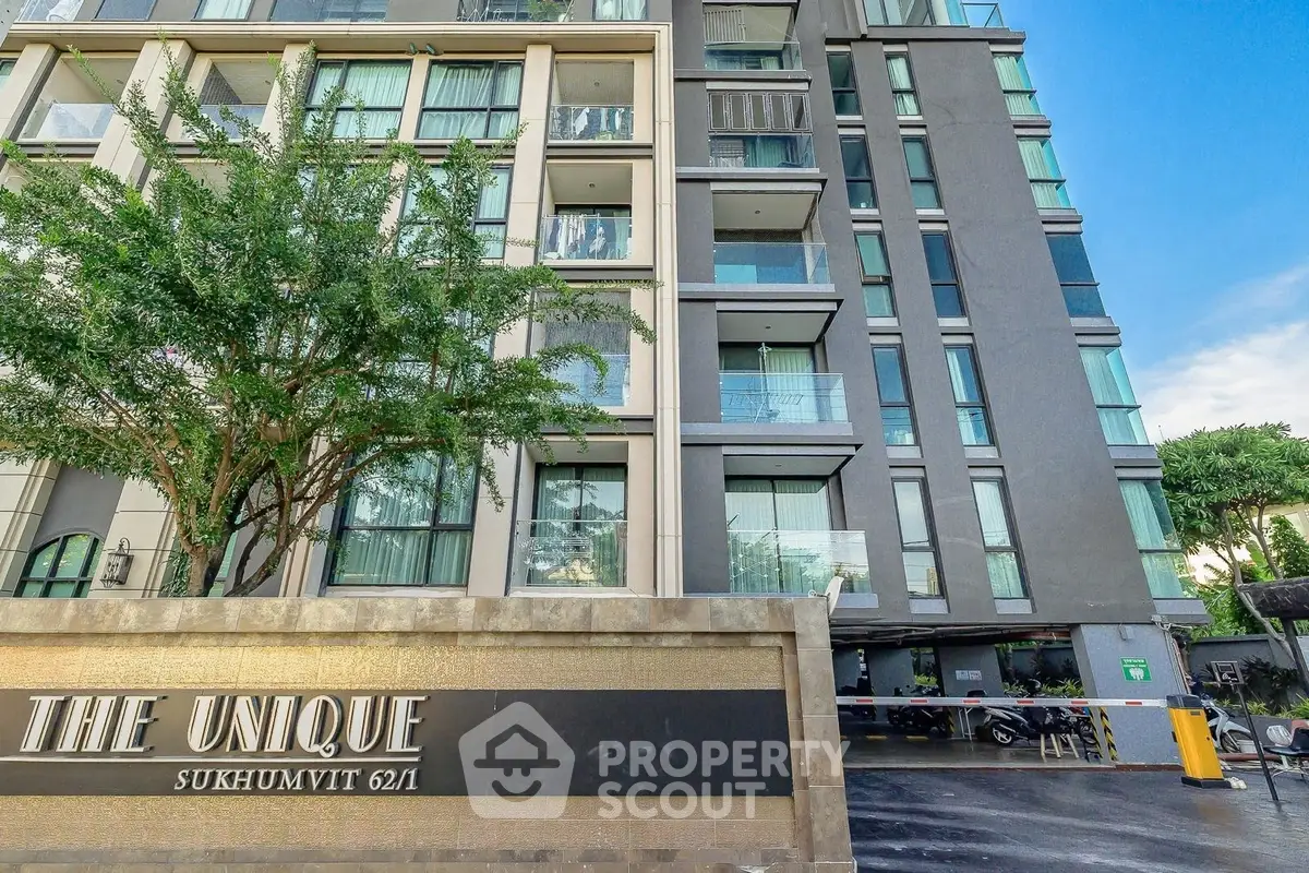Modern condominium building with sleek design and lush greenery in Sukhumvit area.