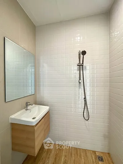 Modern bathroom with sleek shower and stylish vanity in a minimalist design.