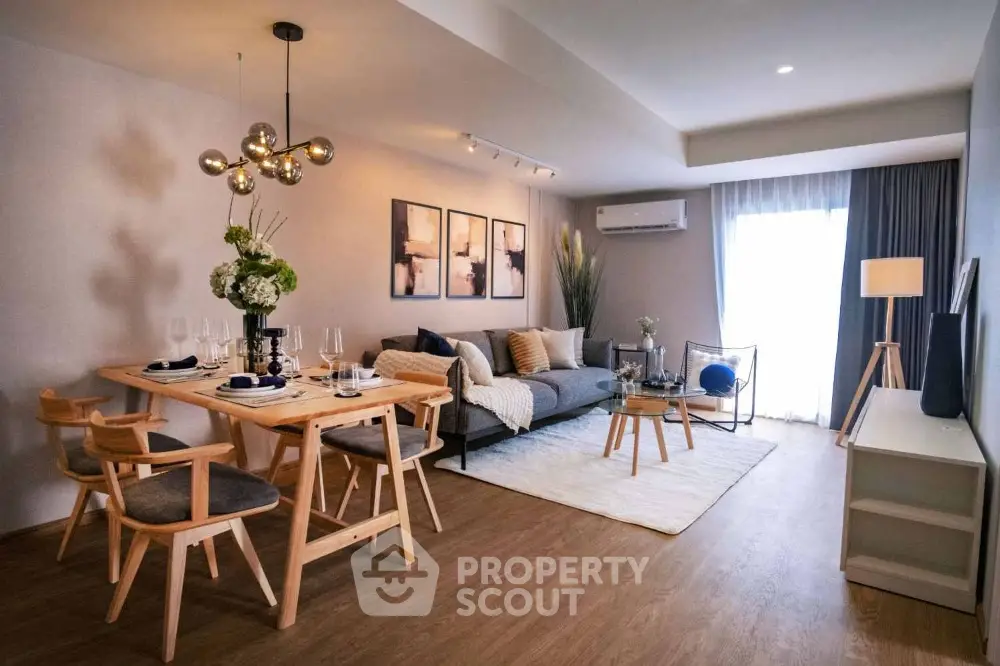 Modern living room with stylish decor and dining area, featuring elegant lighting and cozy ambiance.