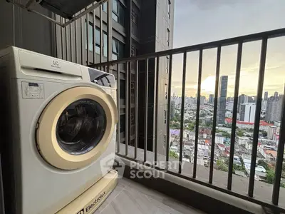High-rise balcony with washing machine and stunning city view at sunset.