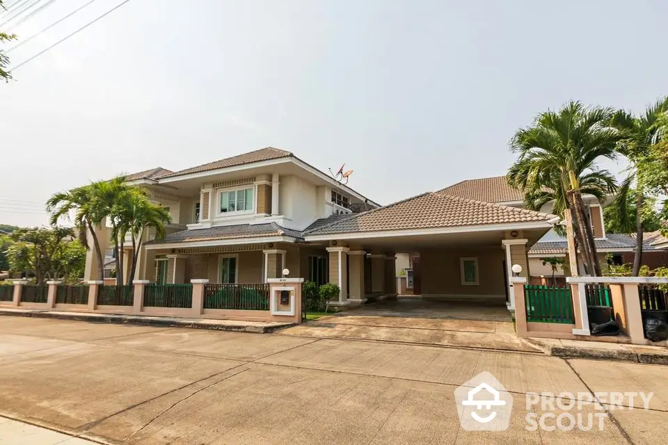 Stunning two-story house with lush greenery and spacious driveway in a serene neighborhood.