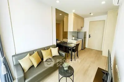 Modern living room with open kitchen, stylish decor, and cozy seating area.