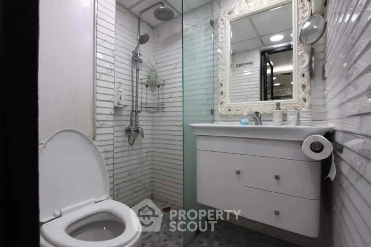 Compact bathroom with modern fixtures and elegant mirror design.