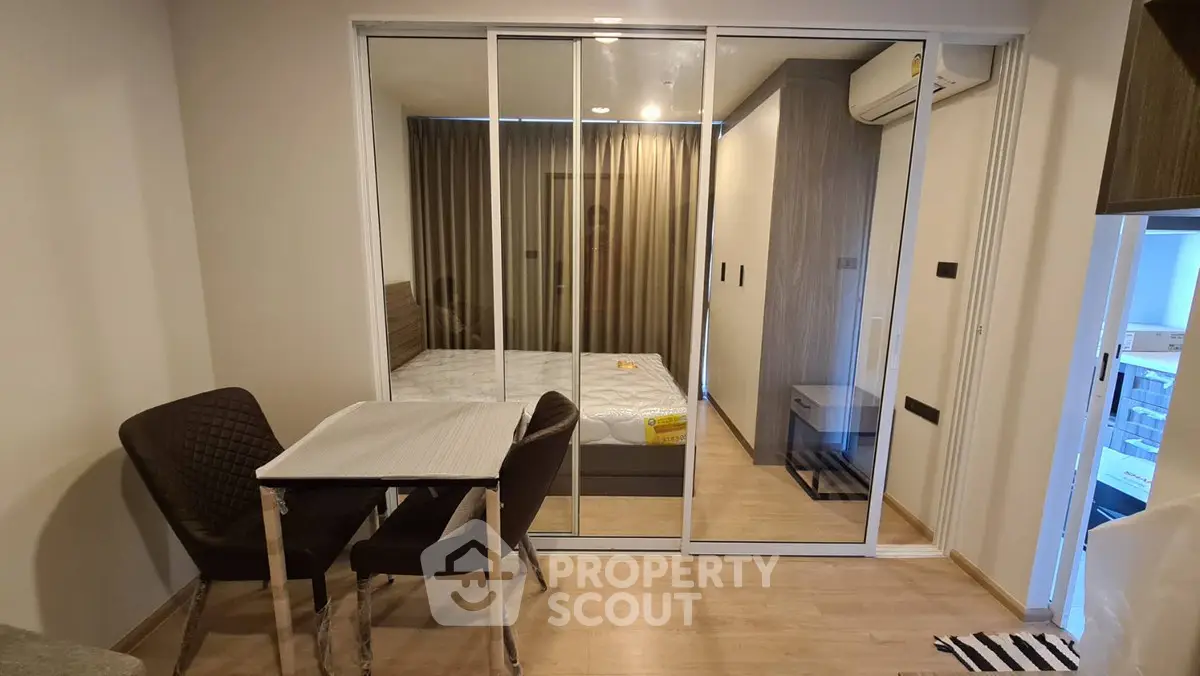 Modern studio apartment with sliding glass doors and cozy dining area.