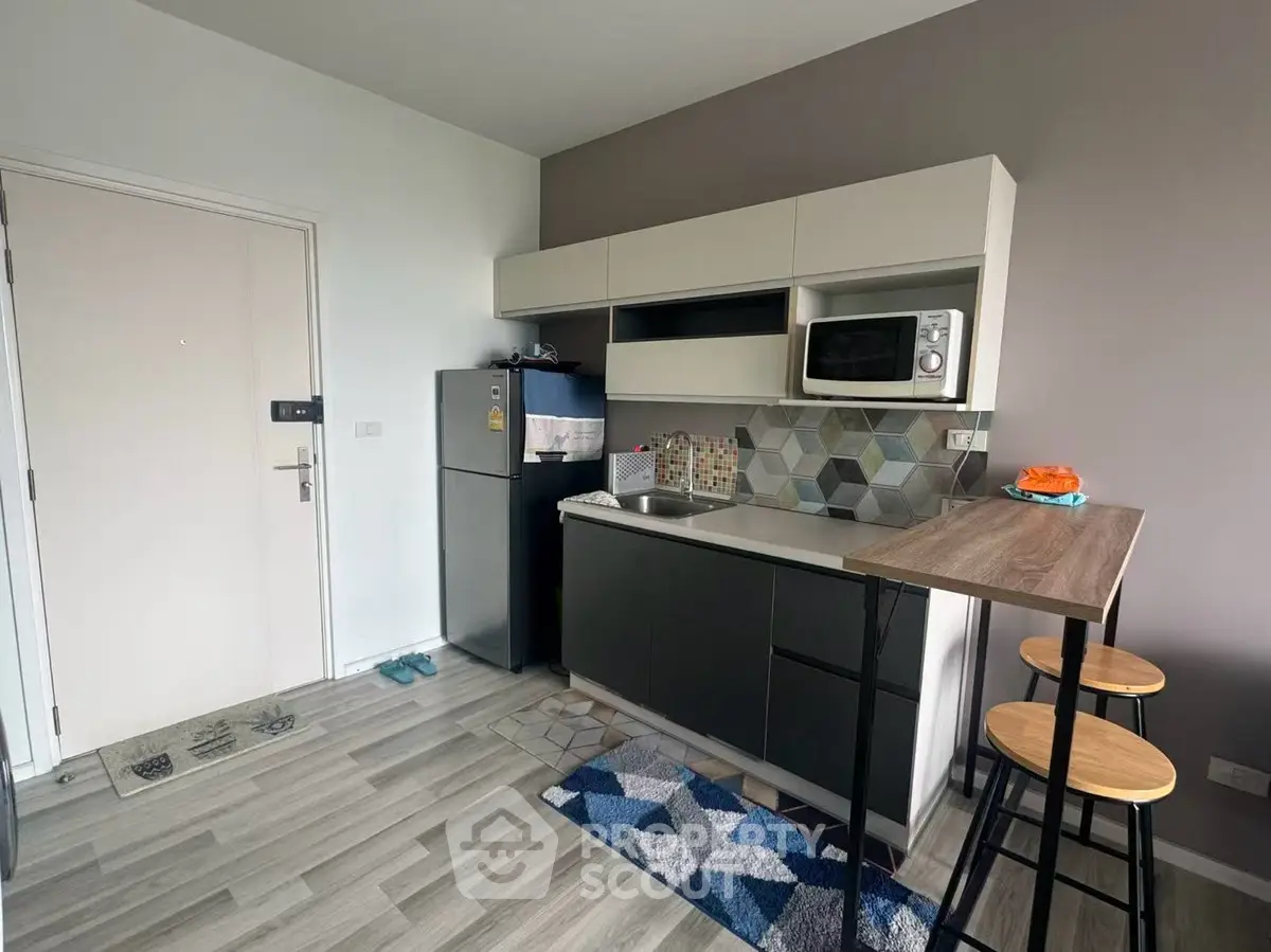 Modern compact kitchen with sleek cabinets and breakfast bar